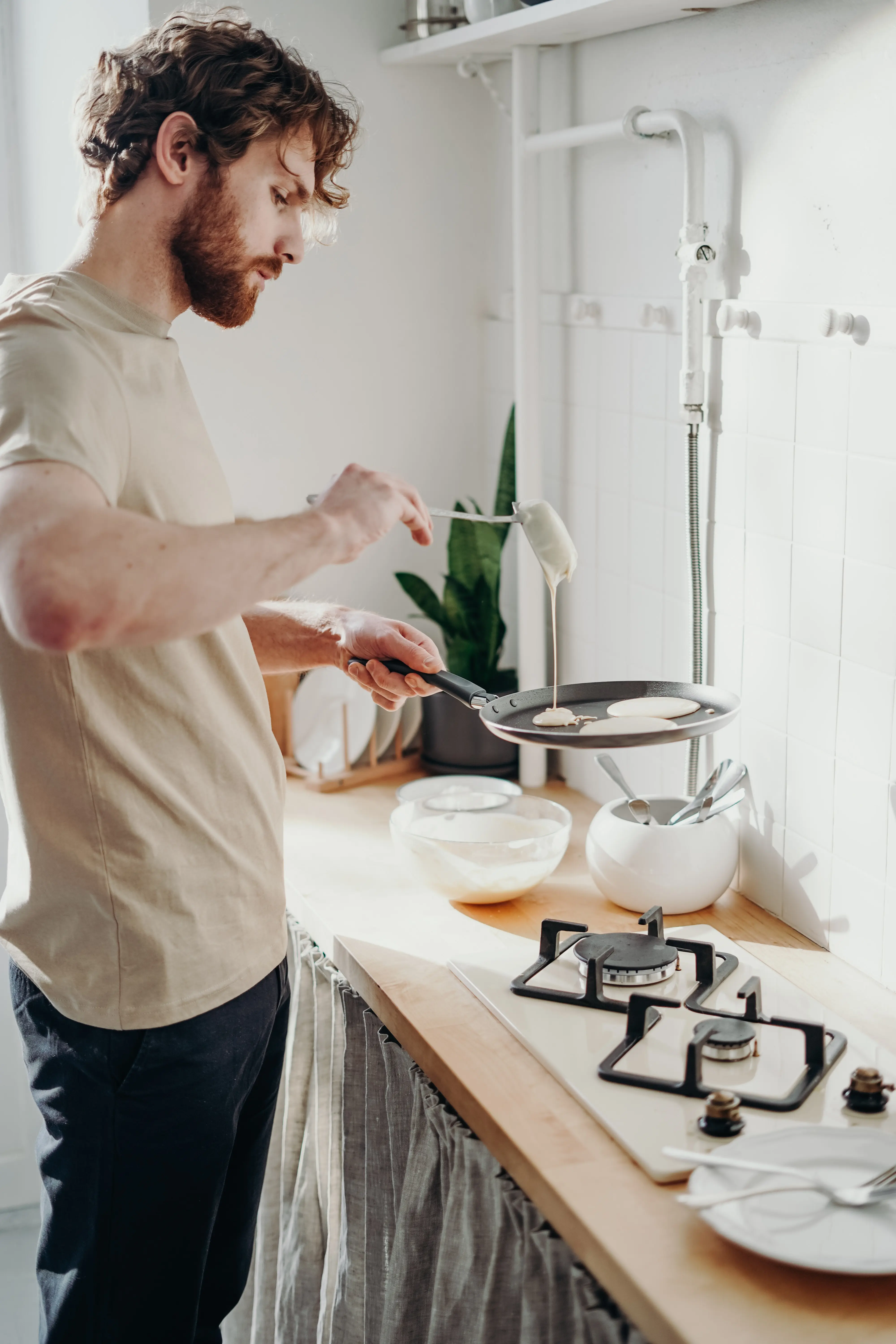A man cooking pancakes in a pan.